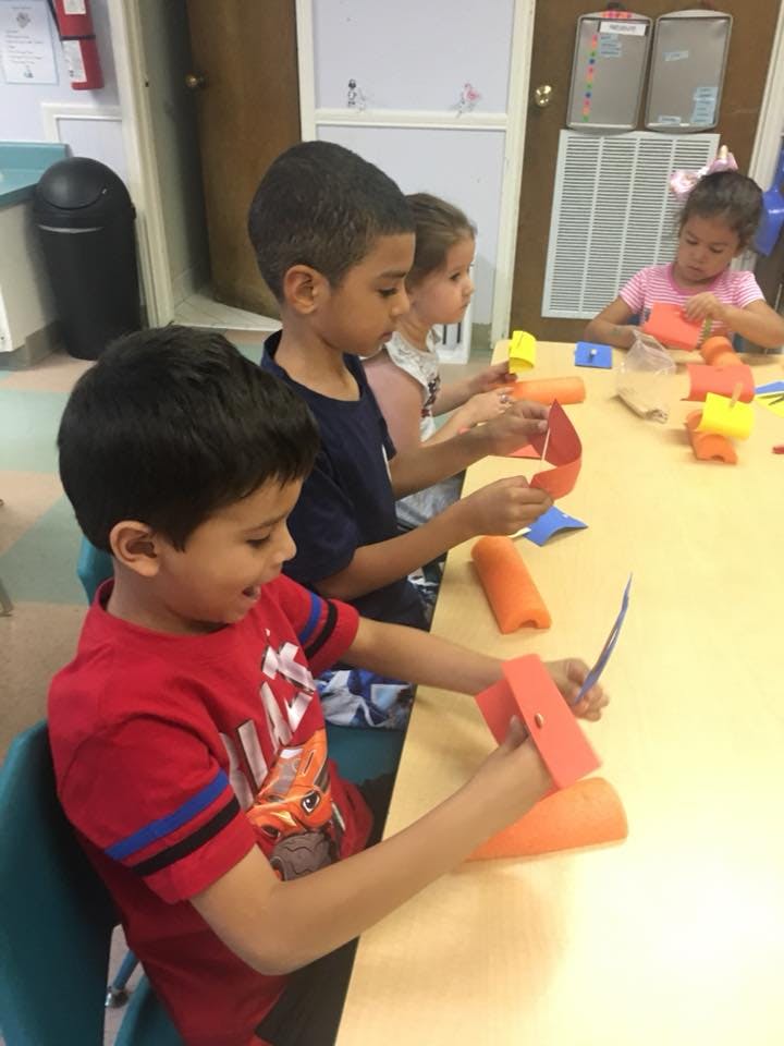Children at a table doing crafts with crafts