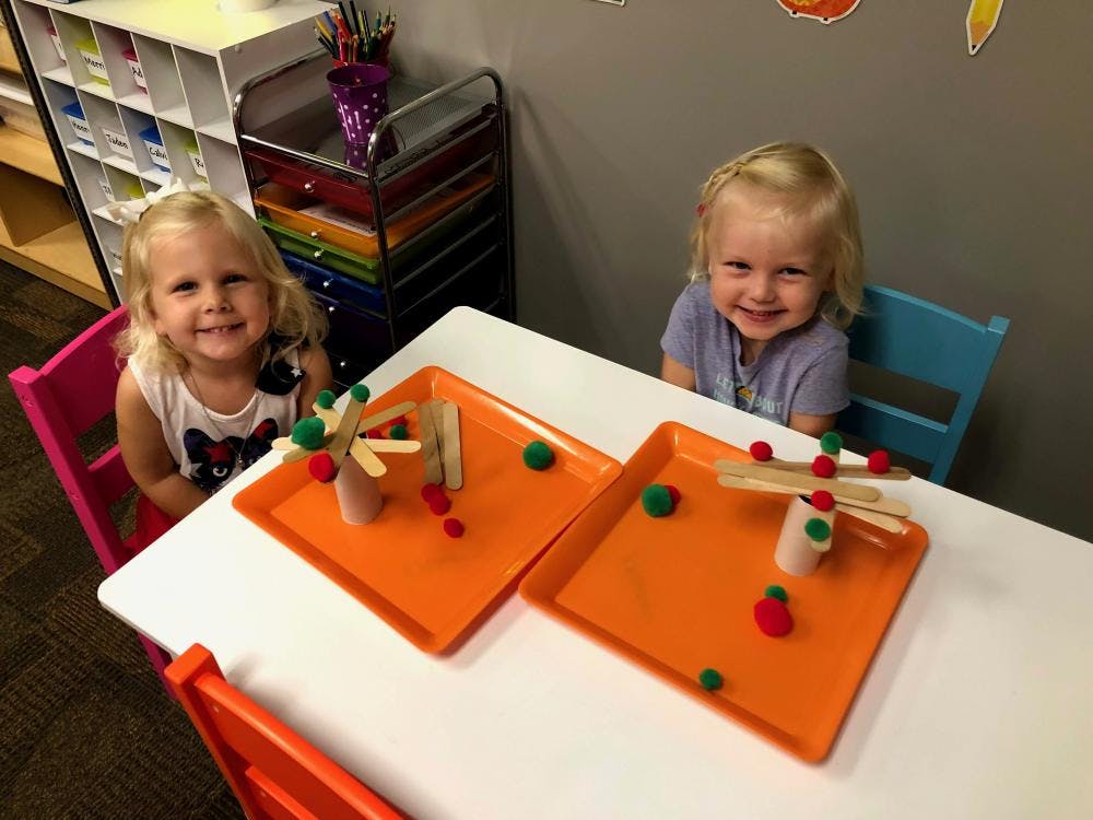 Two children at a table with craft projects
