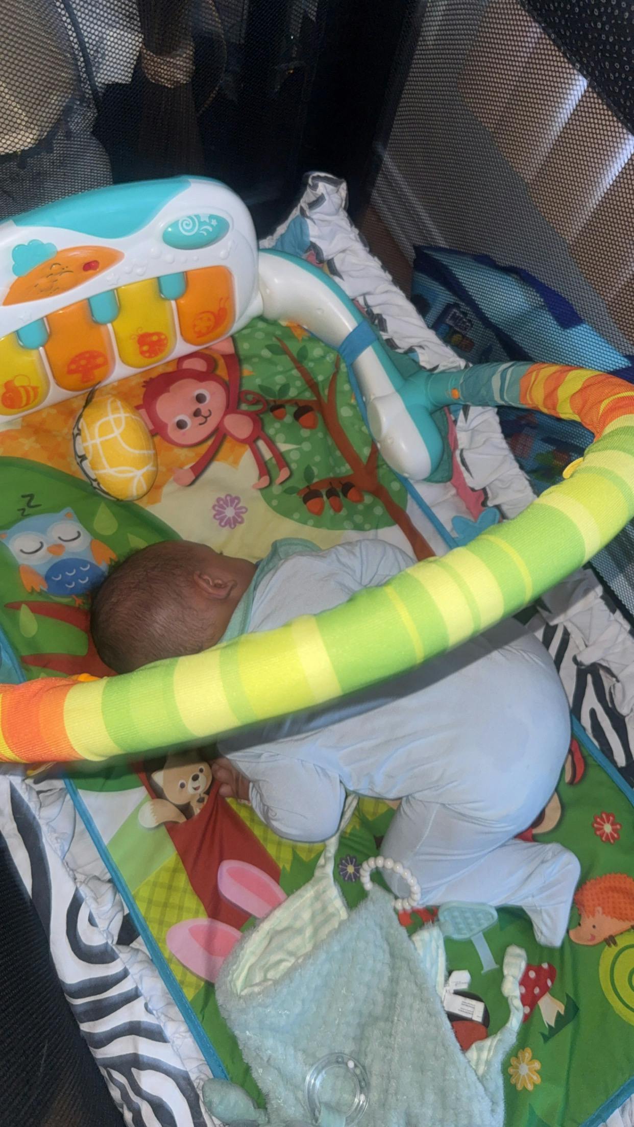 Child lying on a colorful activity play mat
