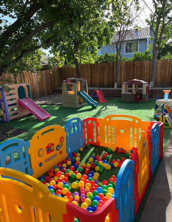 Outdoor play area with slides, playhouses, and a ball pit
