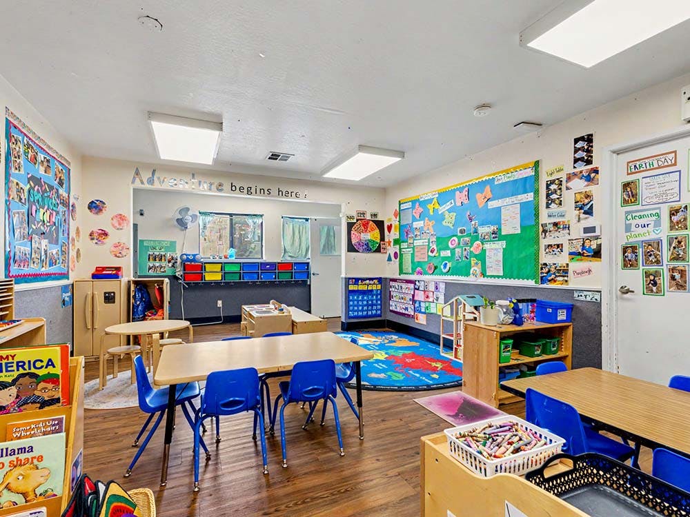 Empty classroom with small tables and chairs, colorful decorations