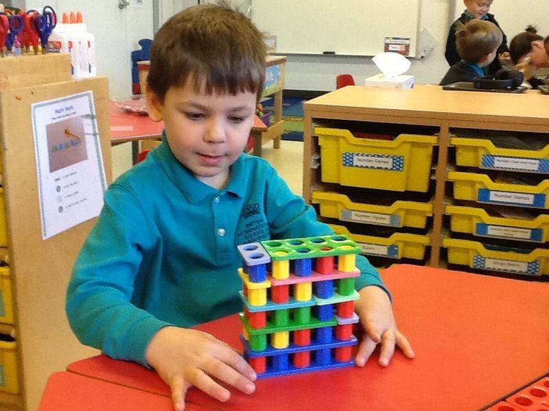 Child playing with colorful building blocks at a table