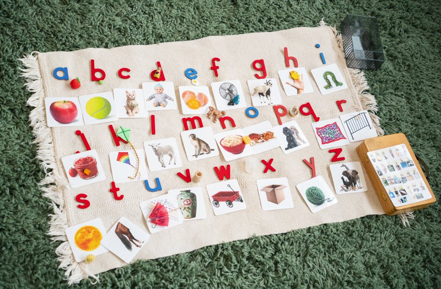 Alphabet letters and picture cards on a light-colored mat