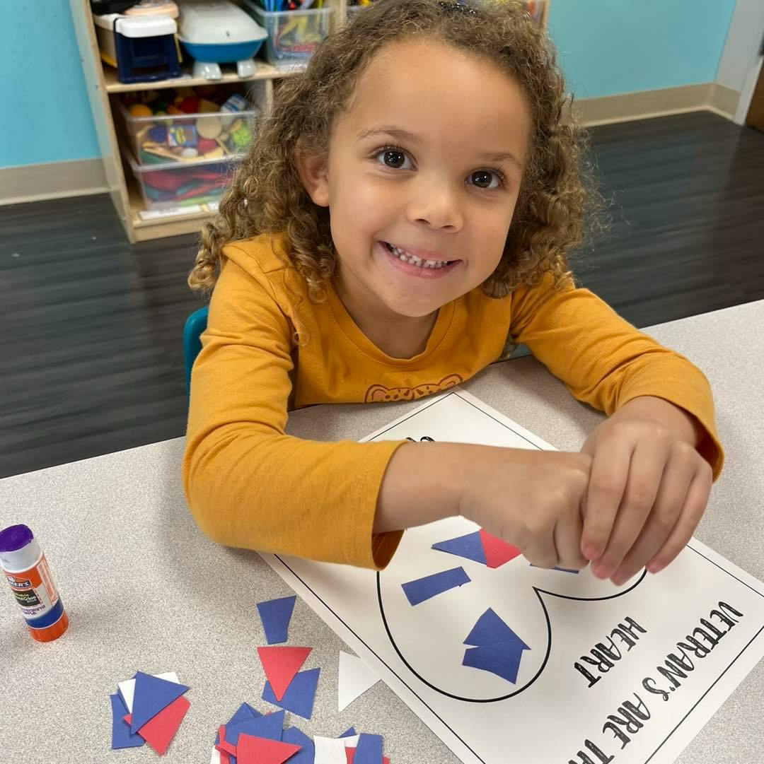 Child doing a craft with paper shapes and glue