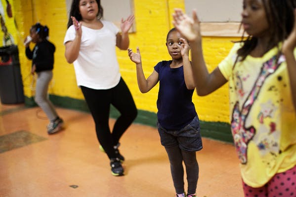 Children dancing with hands raised in a room