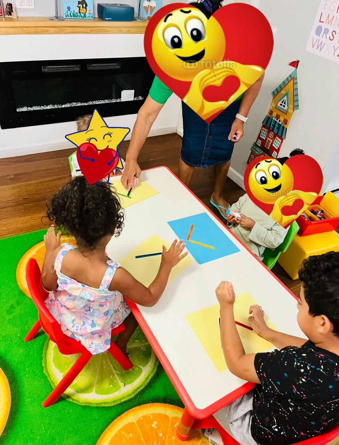 Adult and two children at a table with paper and pencils