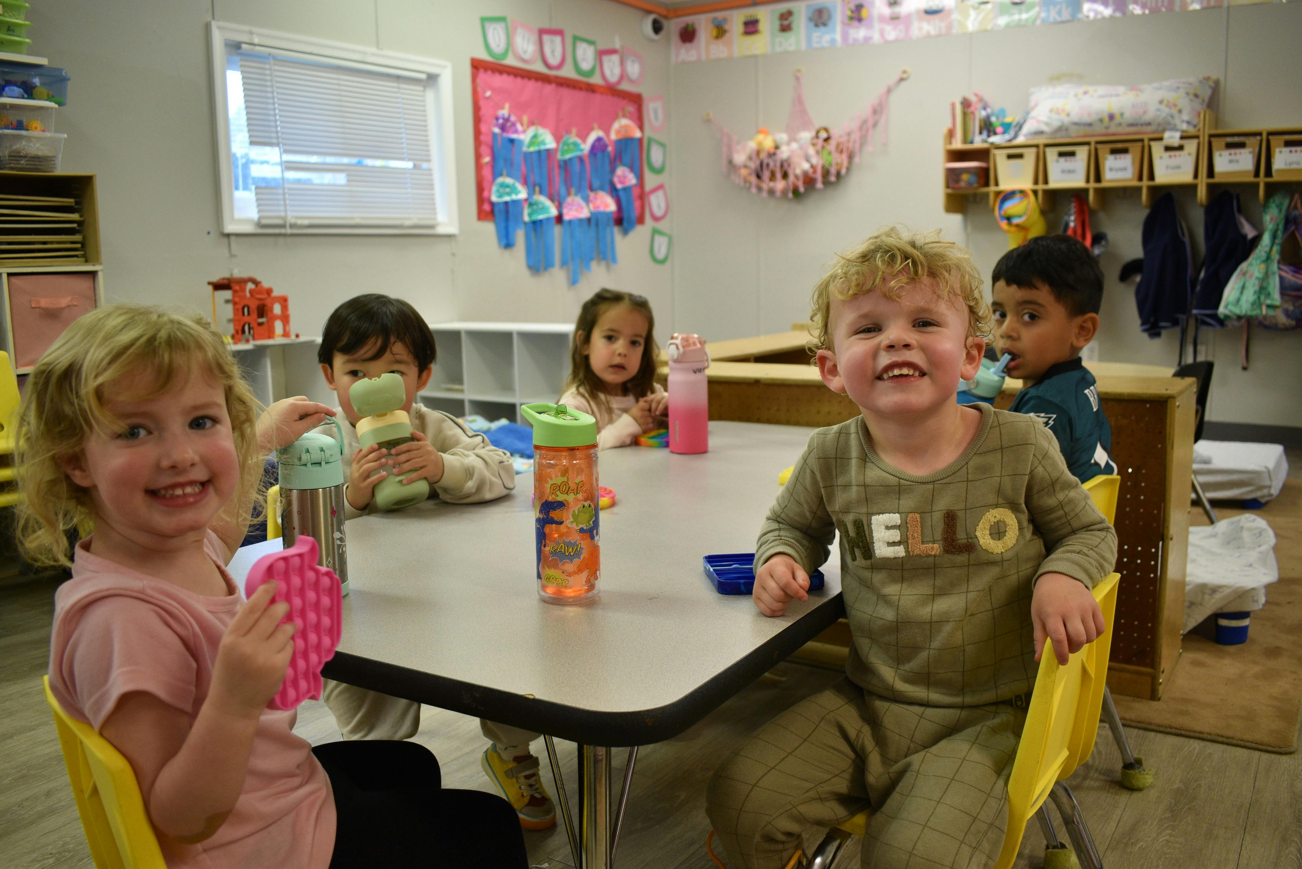 Children sitting at a table in a classroom
