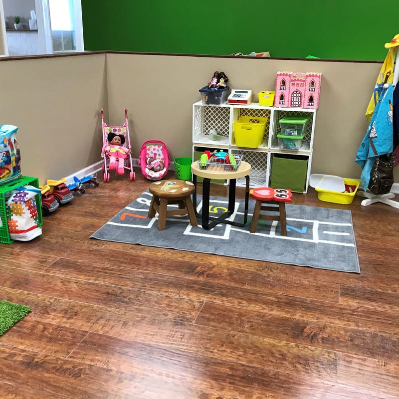 Children's play area with toys, small table, and stools