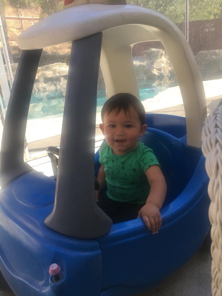 Child sitting in a blue toy car