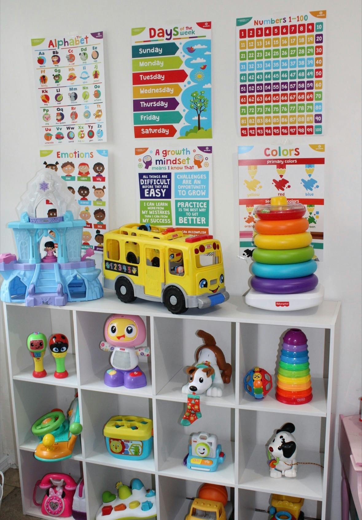 white shelves filled with children's toys and educational posters on the wall