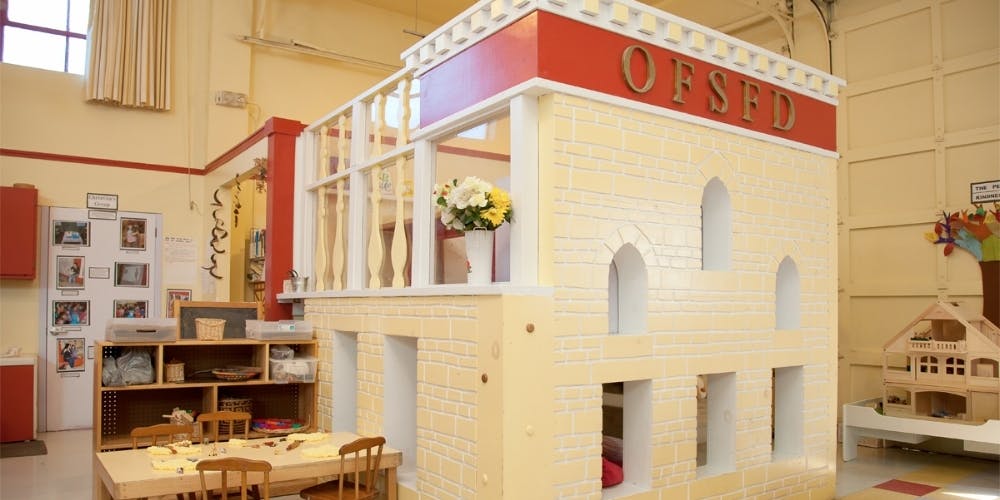 Playhouse with "OFSTED" sign in a classroom