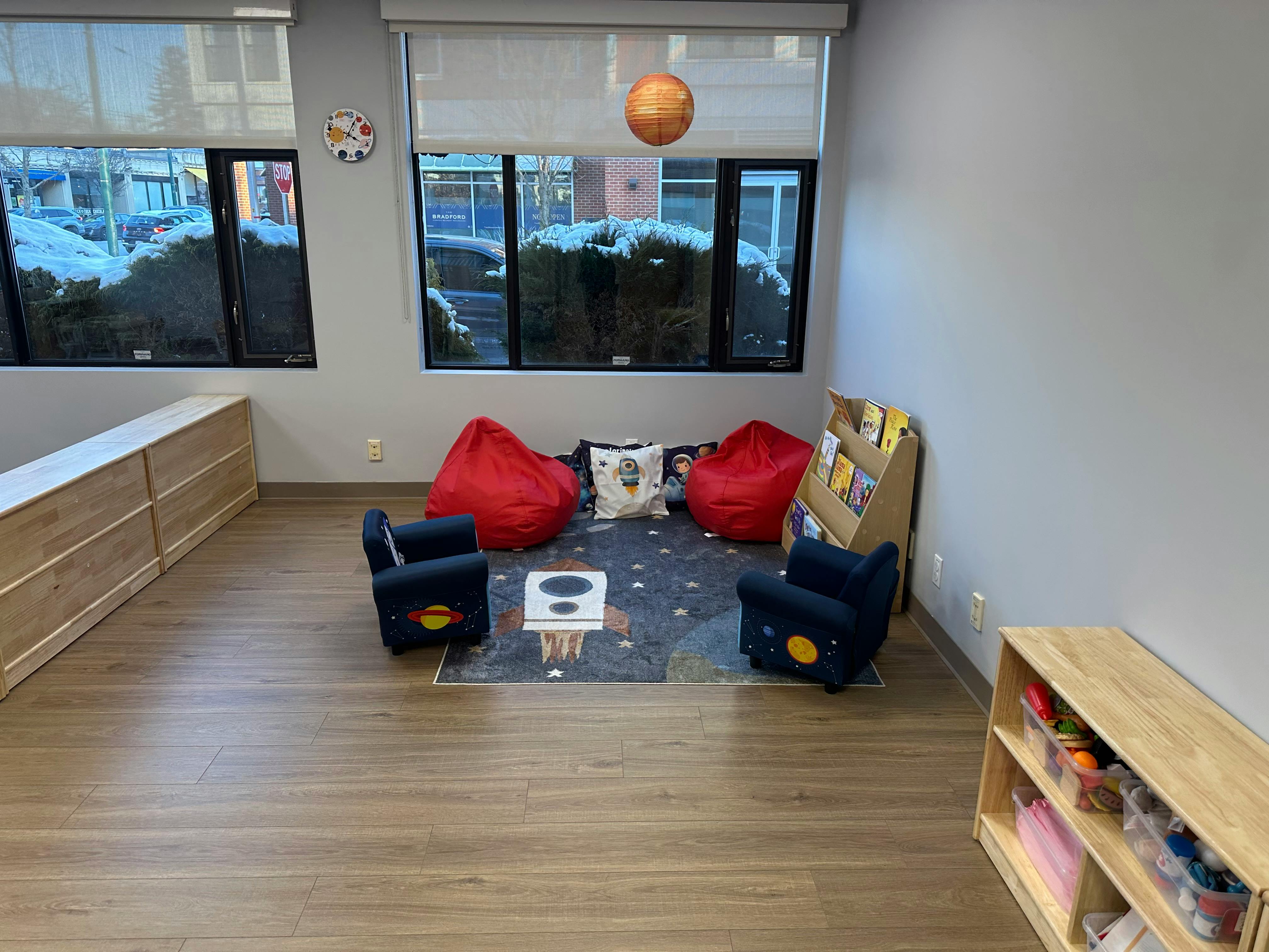 Children's reading nook with bean bags, small chairs, and a bookshelf