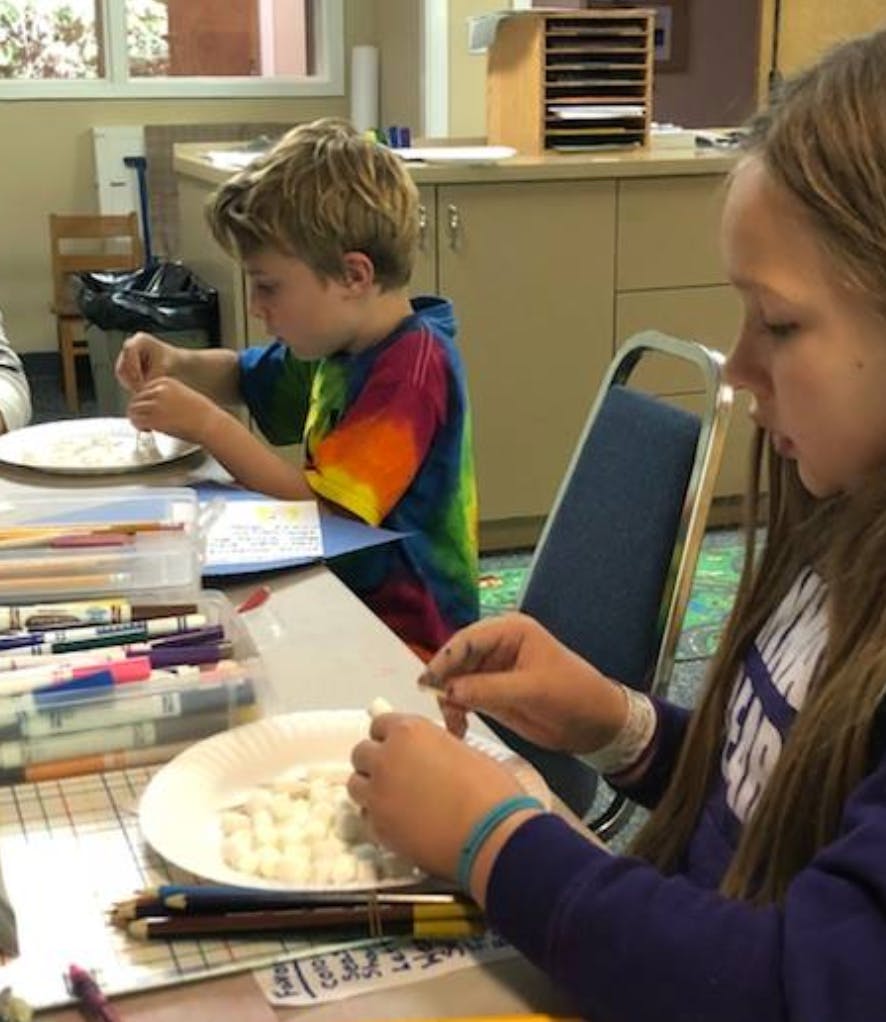 Two children working on crafts at a table