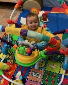 Child sitting in a play gym
