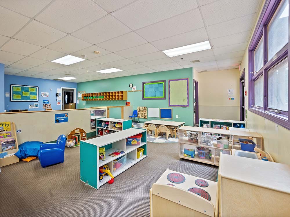 Empty classroom with colorful walls and children's furniture and toys