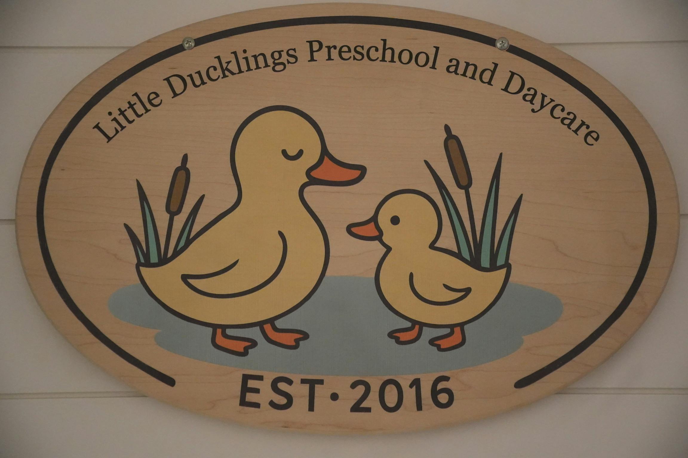 Wooden oval sign for Little Ducklings Preschool and Daycare with duck art
