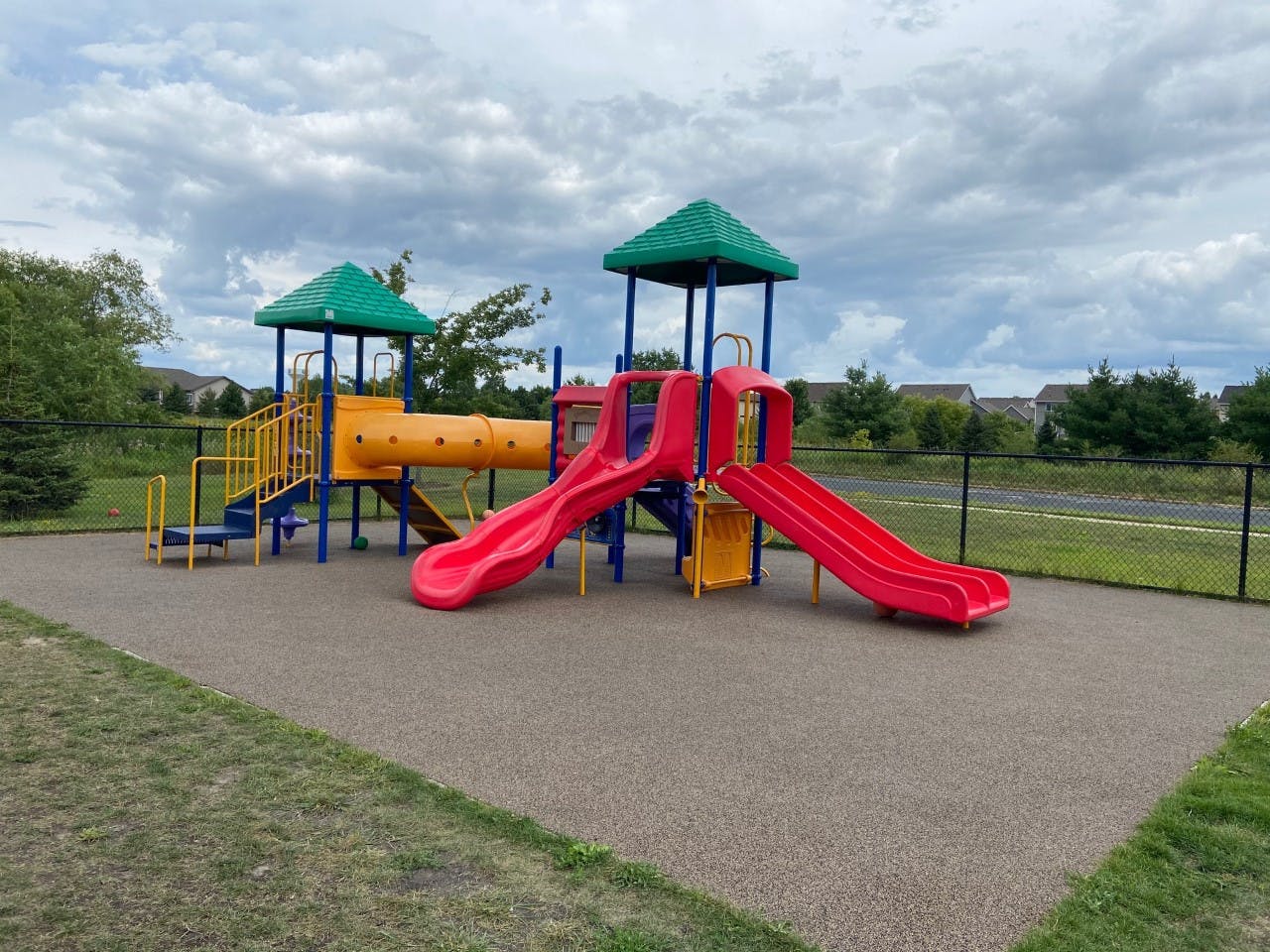 A colorful outdoor playground structure with slides and tunnels