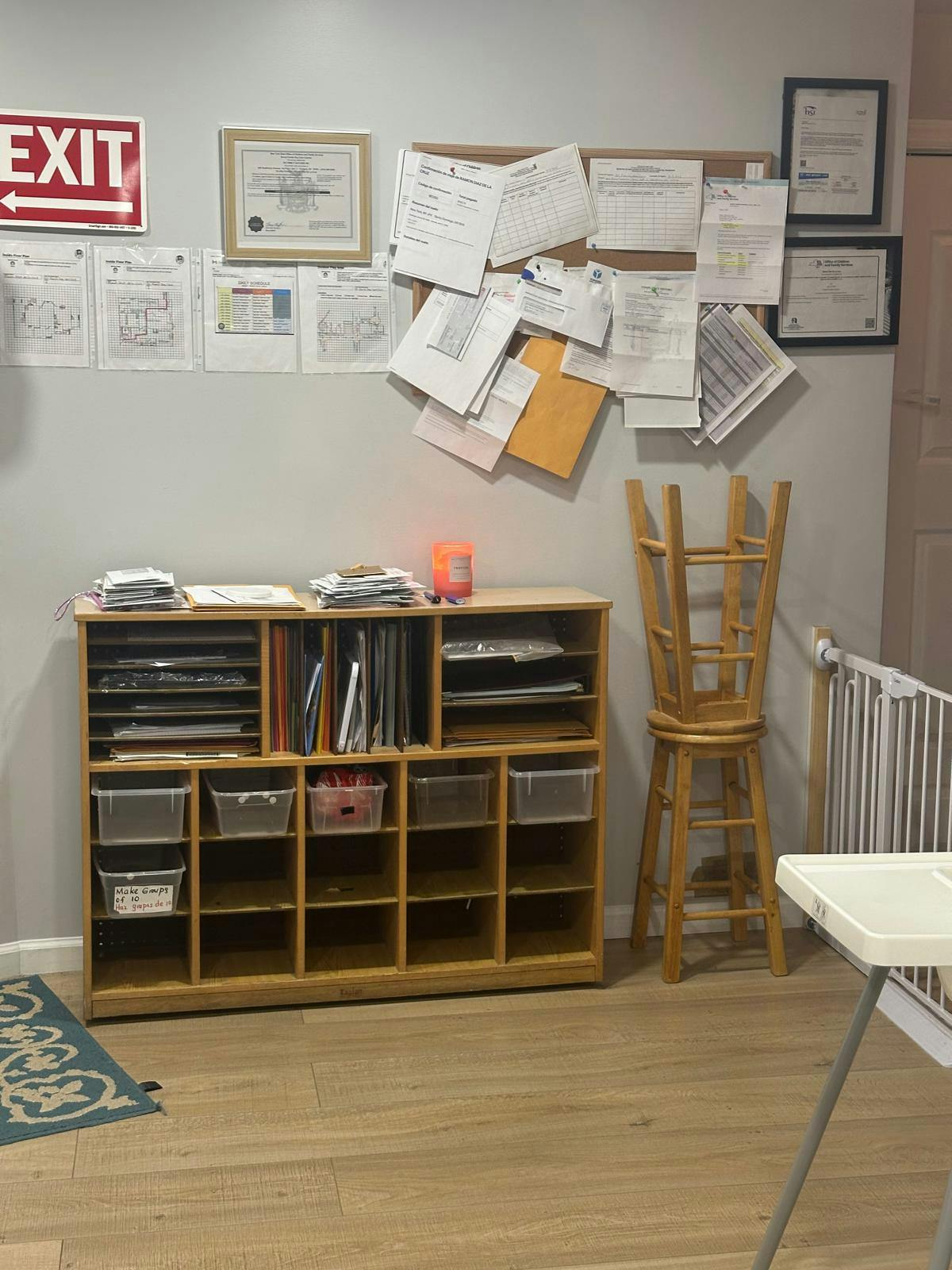 Storage unit with shelves and bins, bulletin board with papers, and an exit sign