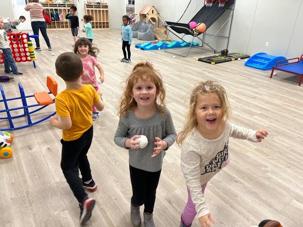 Children playing in a room with various play equipment