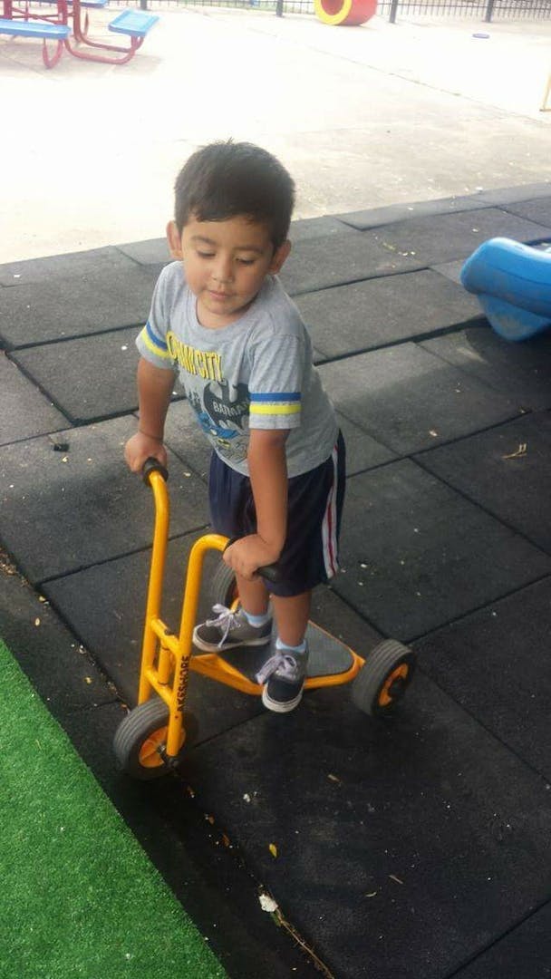 Child on a yellow scooter on a playground