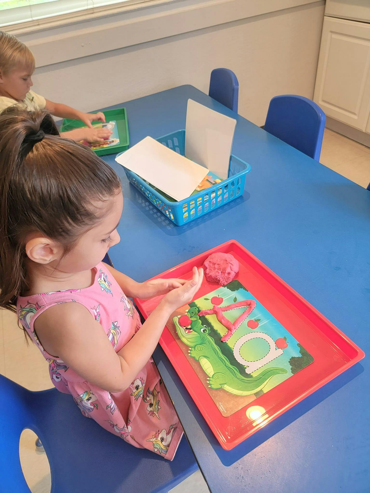 Child playing with modeling clay at a table