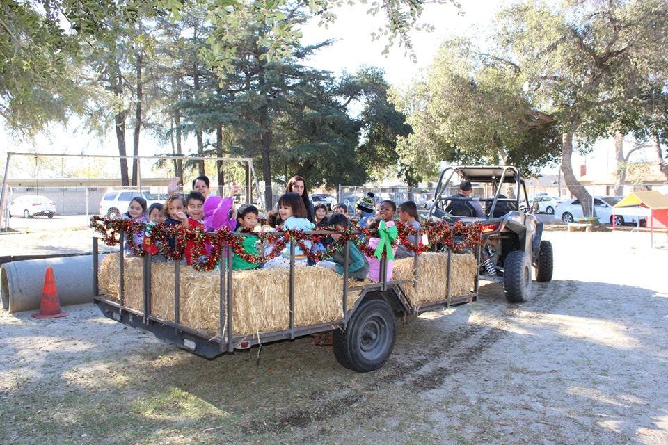 Children and adults riding in a hayride trailer