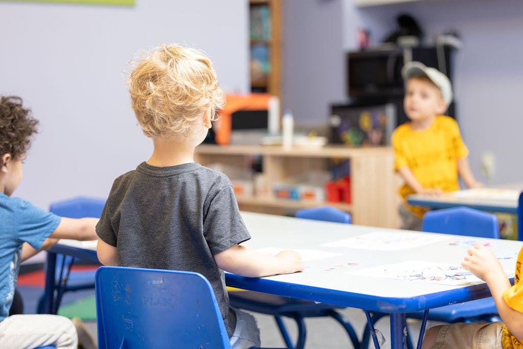 Children sitting at tables in a classroom