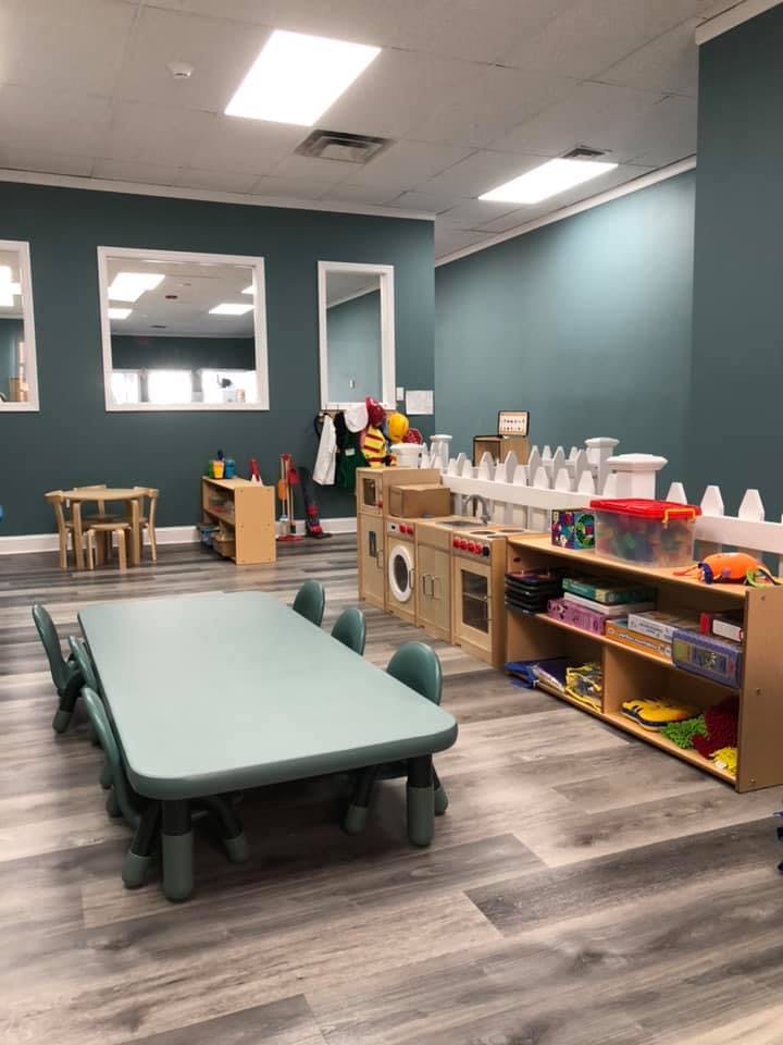 Playroom with small tables and chairs, and a play kitchen set