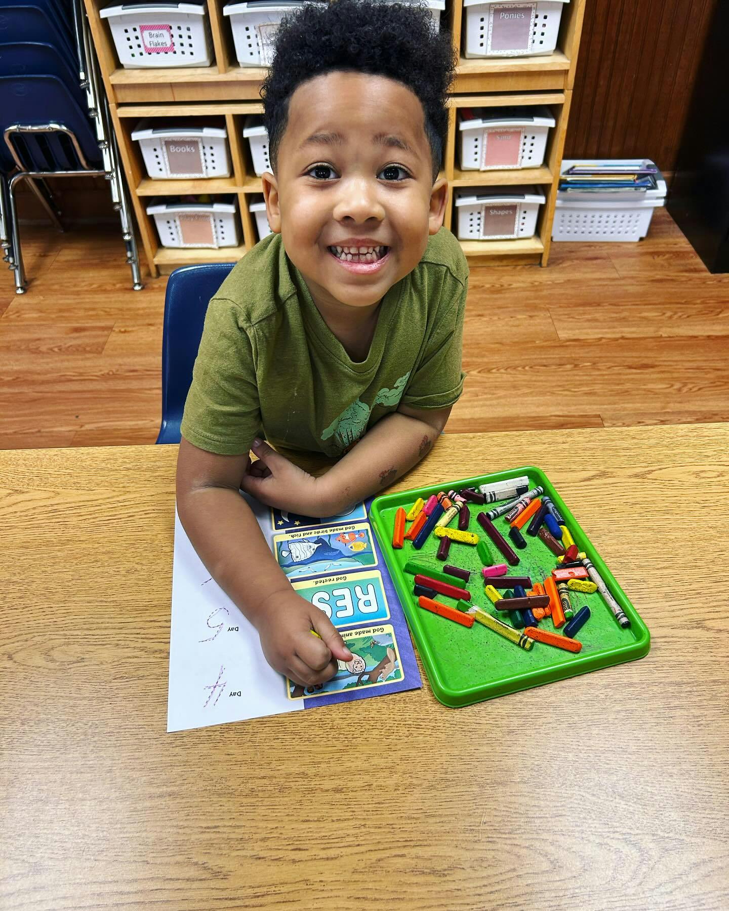 Child drawing with crayons at a table