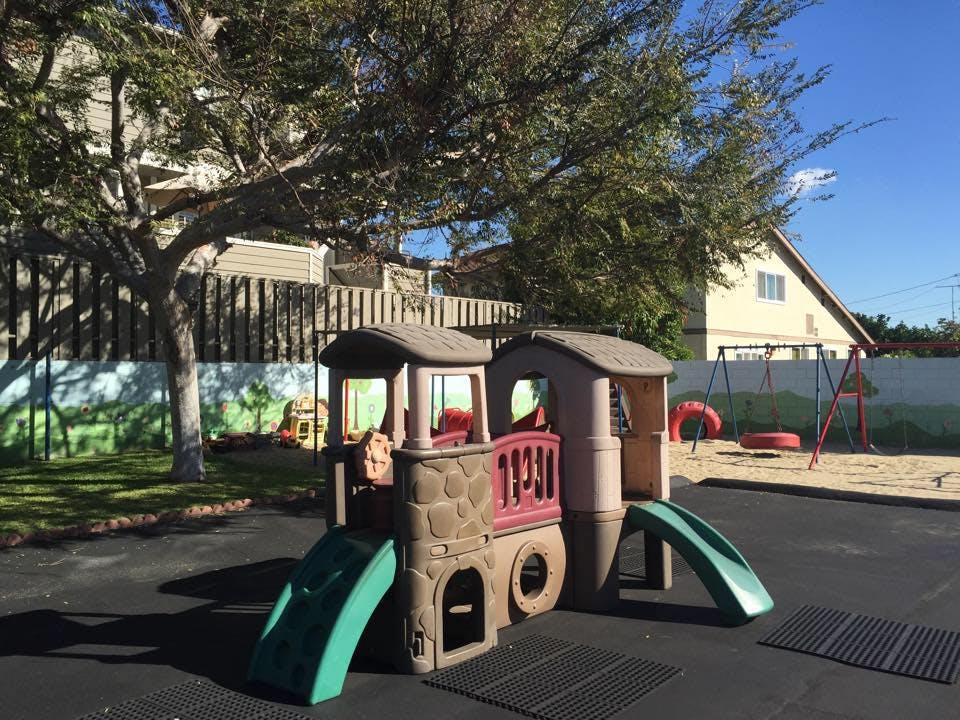 Playground with a train-shaped play structure and slides