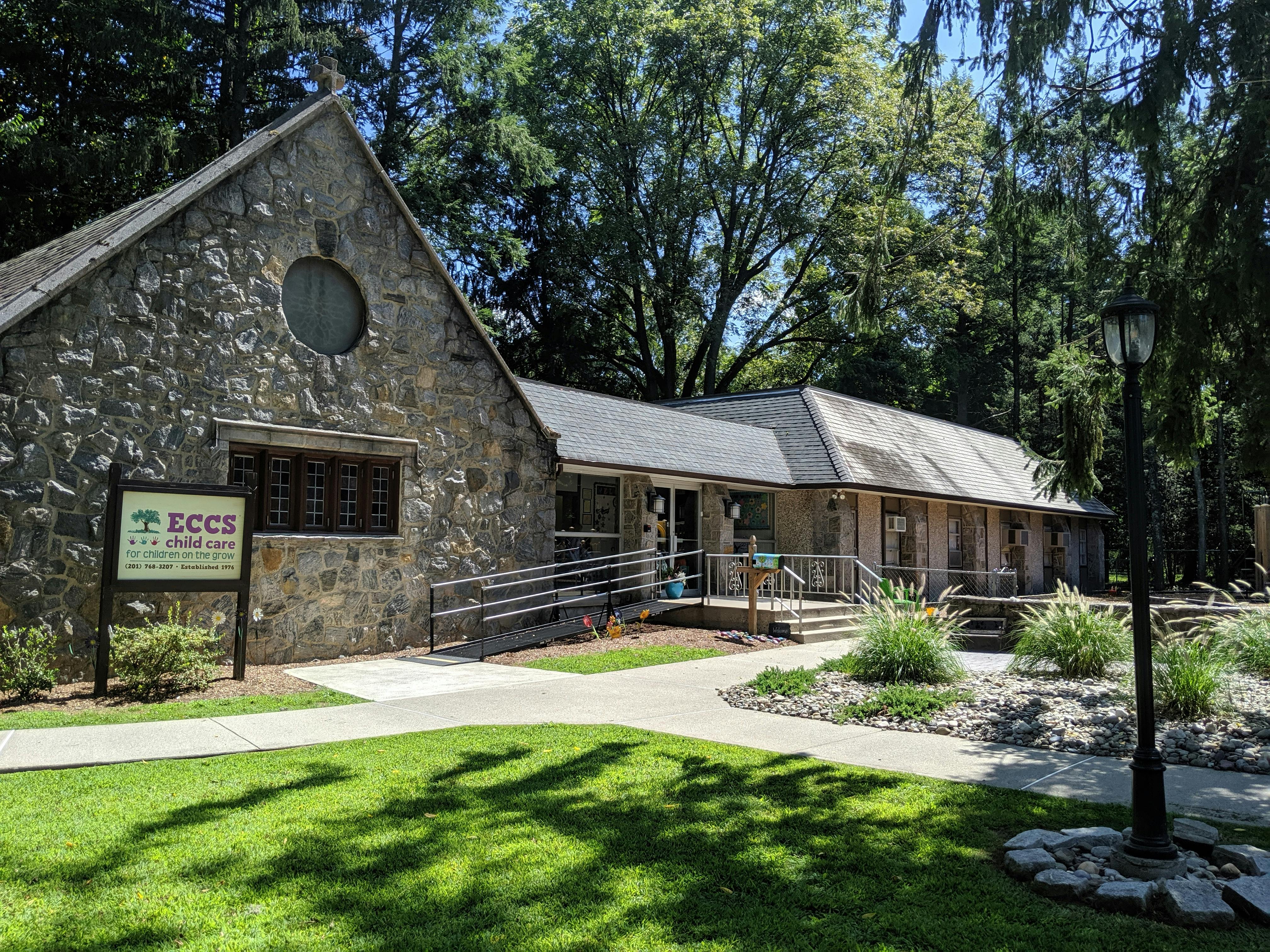 Stone building with a sign and a long wooden building next to it