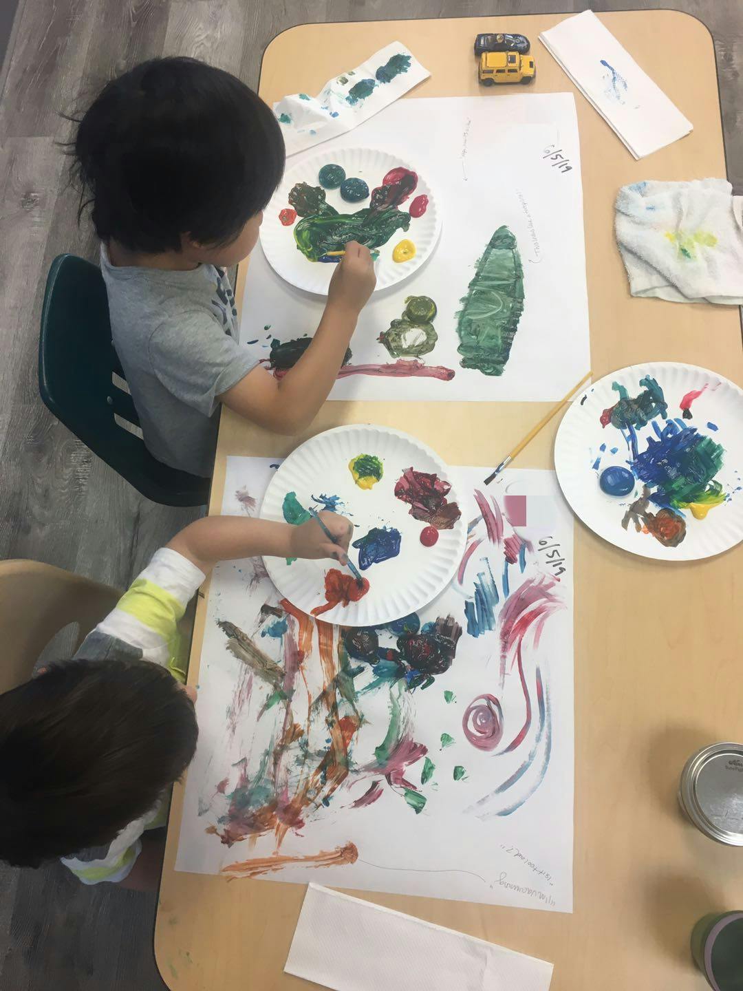 Two children painting at a table