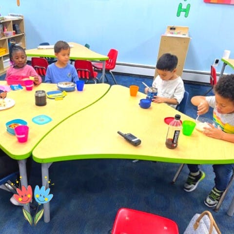Children eating at a table in a classroom