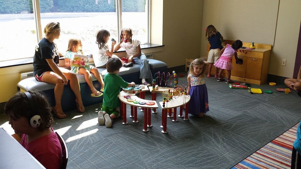 People and children playing in a room