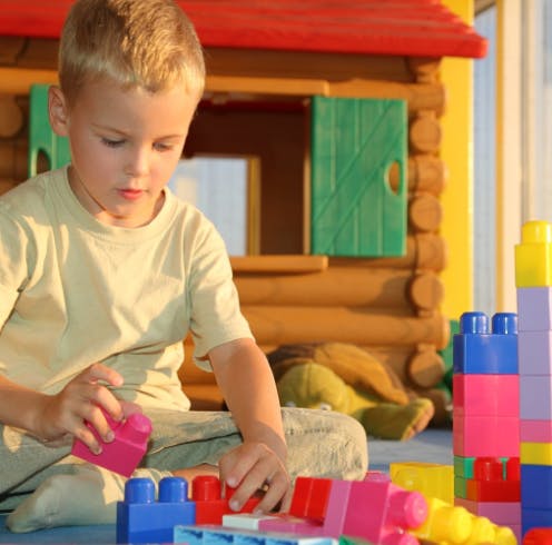 Child playing with colorful building blocks