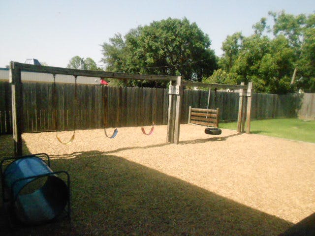 Swing set with three swings and a tire swing on a playground