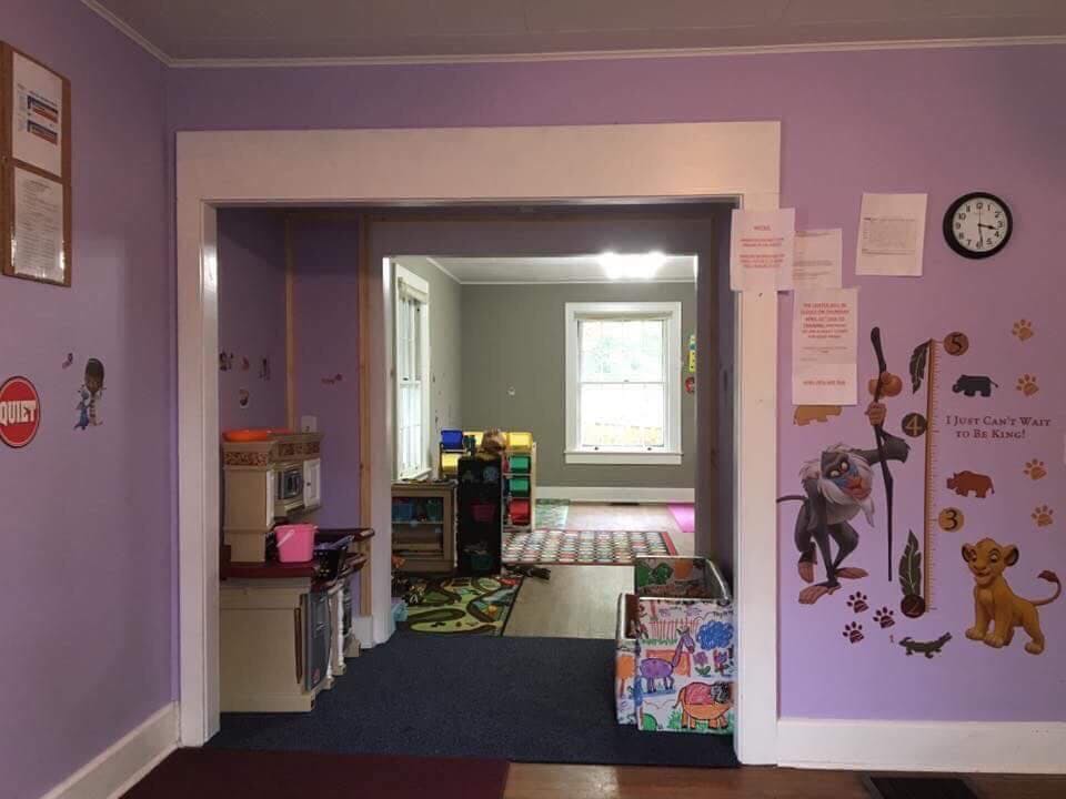 Playroom with purple walls and an open doorway to another room