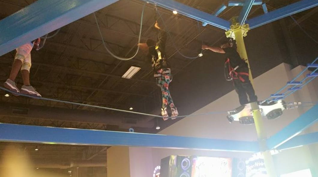 People on an indoor ropes course