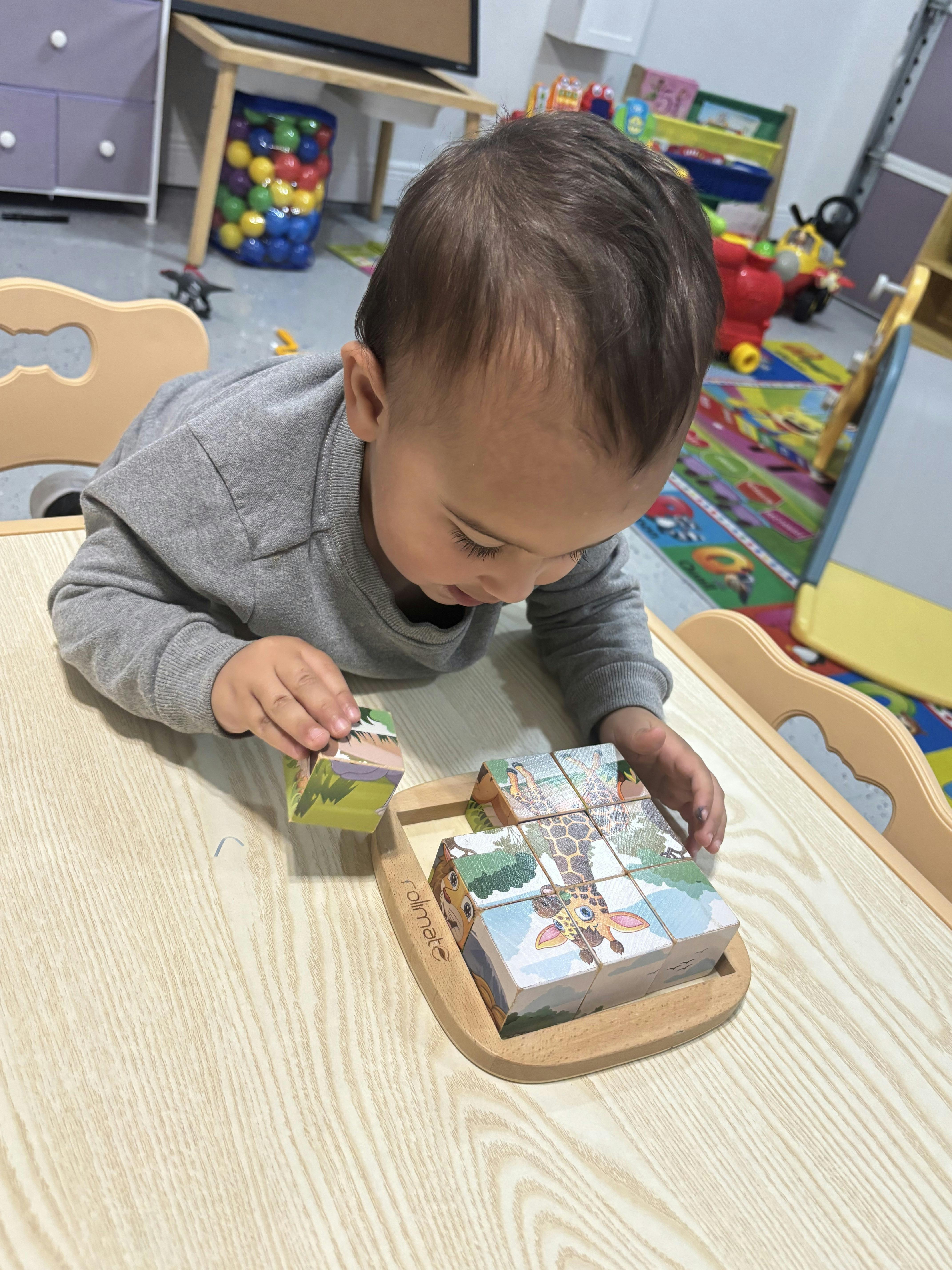 Child playing with puzzle blocks on a table