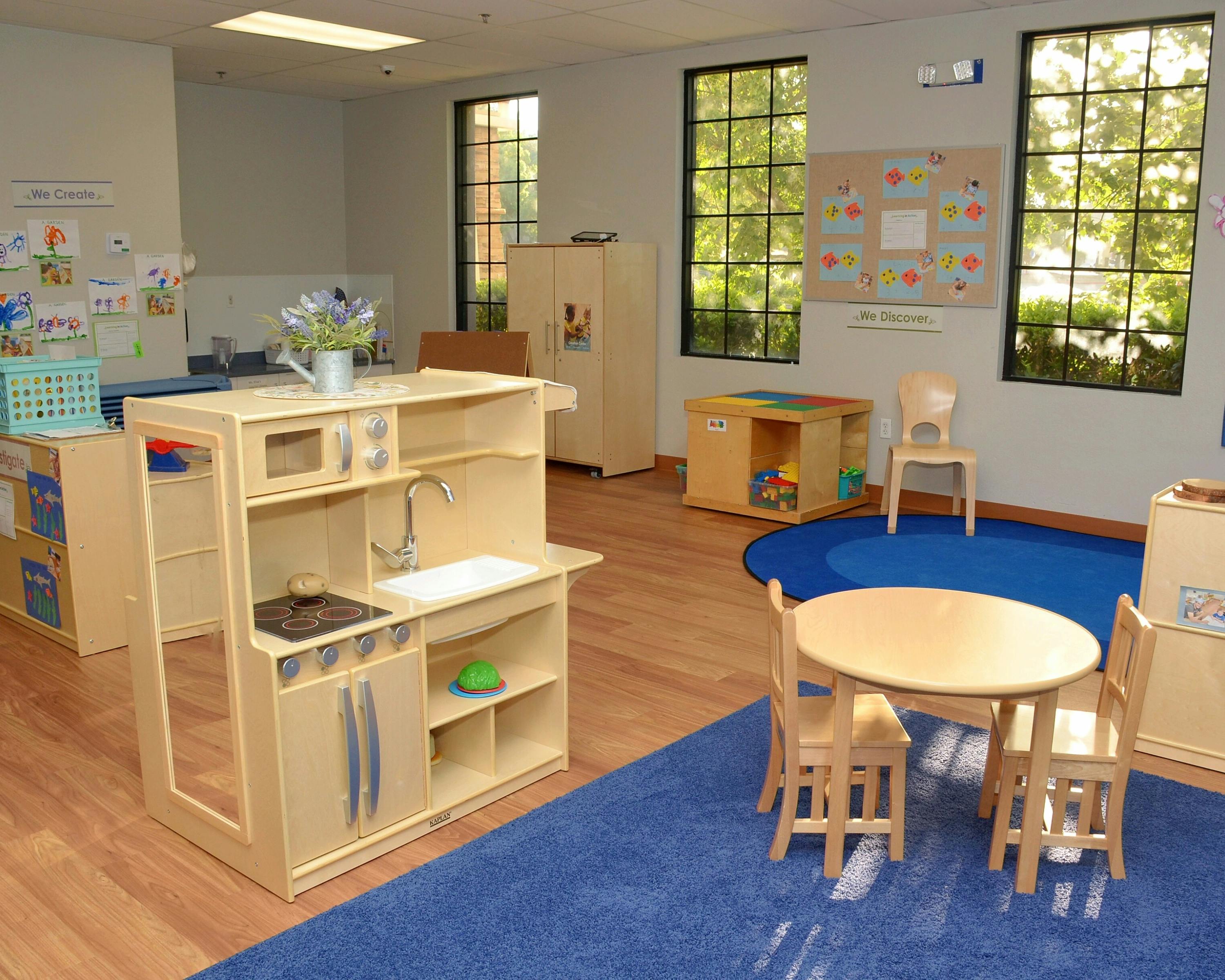 Play kitchen and small table with chairs in a classroom