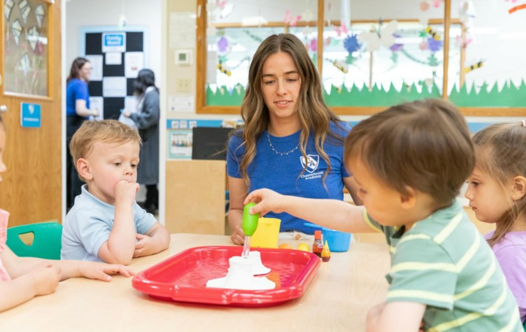 Teacher and young children doing a science experiment in a classroom