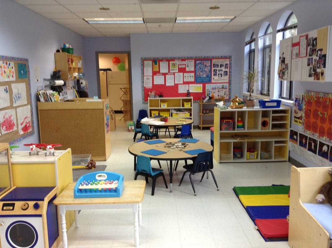 Classroom with small tables and chairs, shelves, and bulletin boards