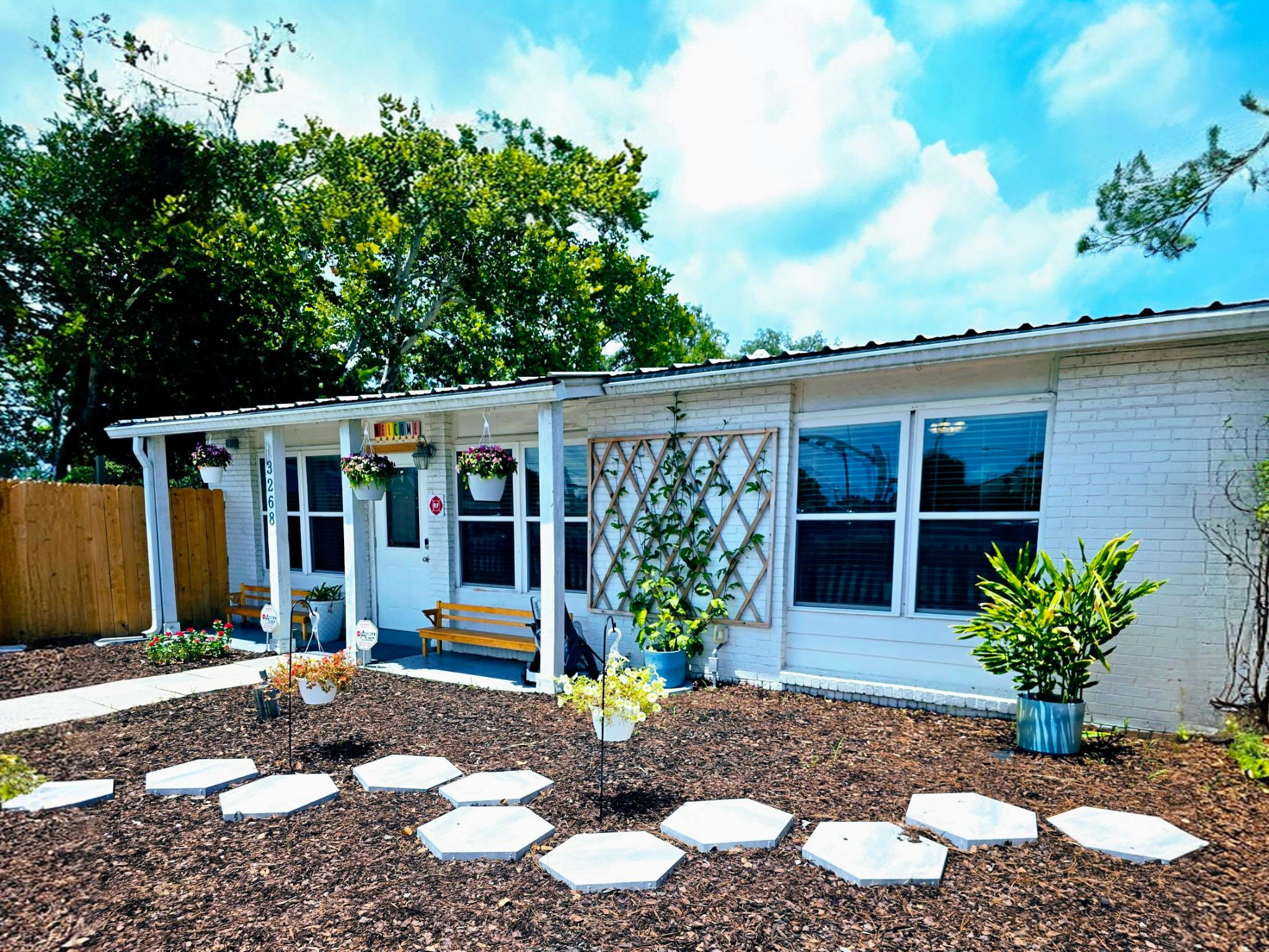 White house with a porch and stepping stones leading to the entrance