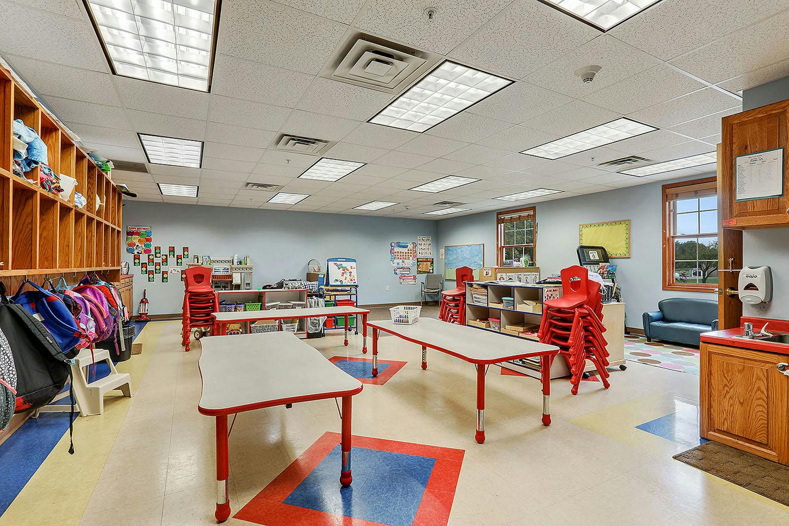 Empty classroom with small tables and chairs