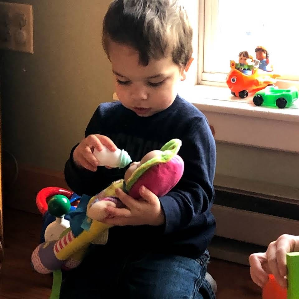 Child feeding a doll with a bottle