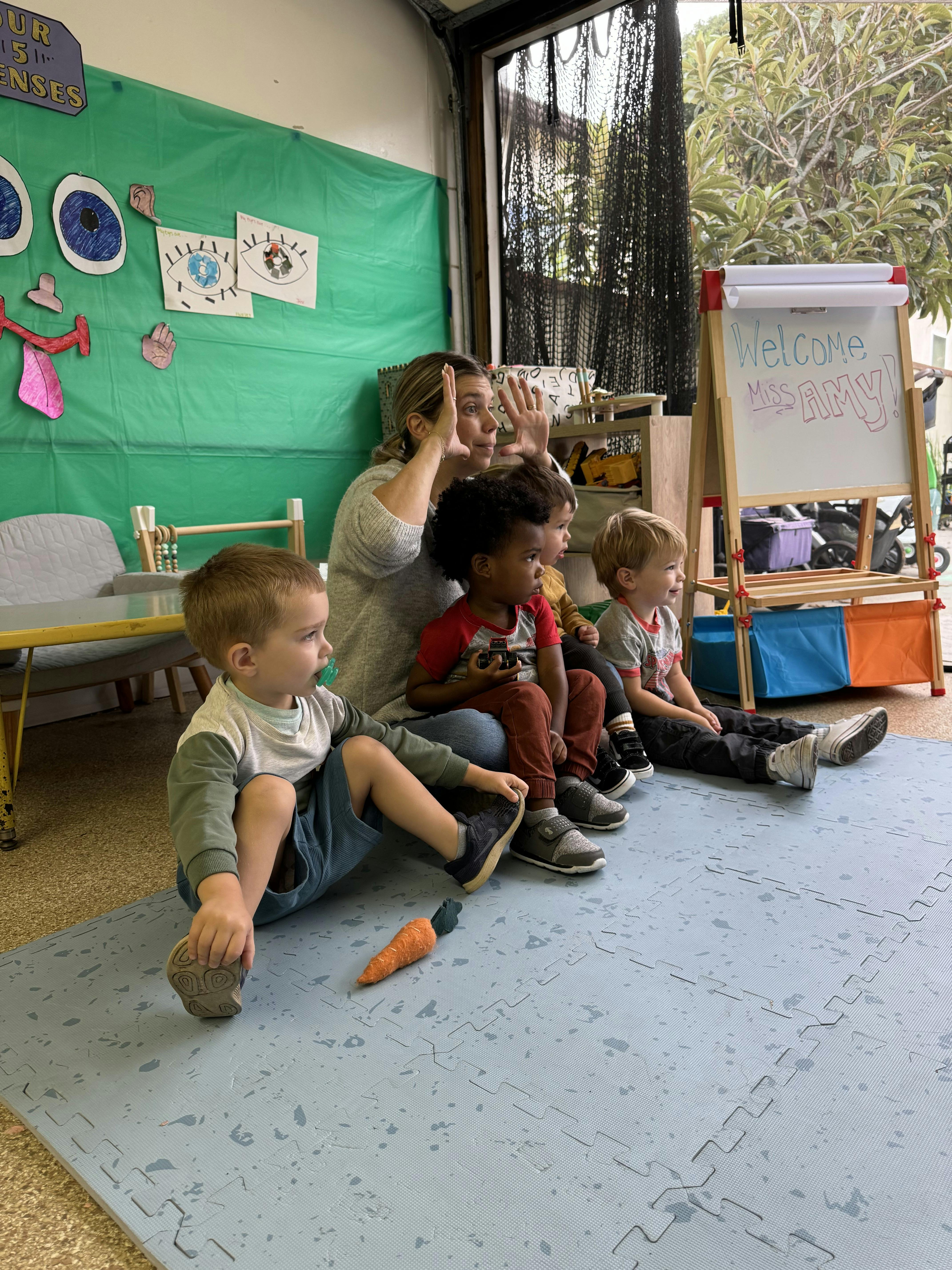 Adult leading a group of children in a classroom activity