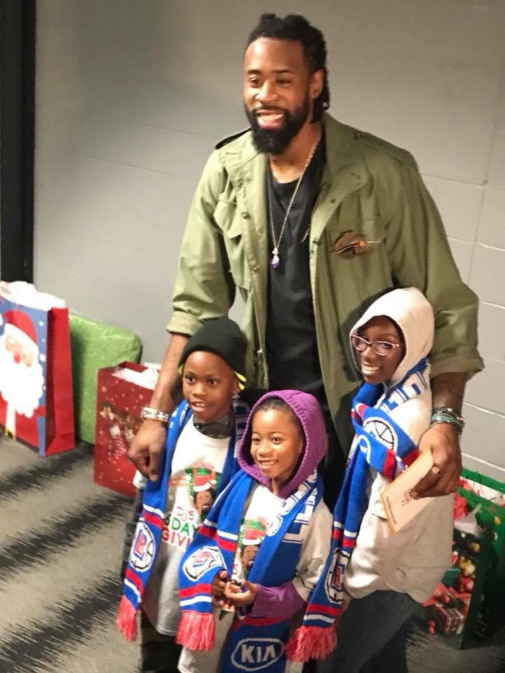 Person standing with three children wearing scarves