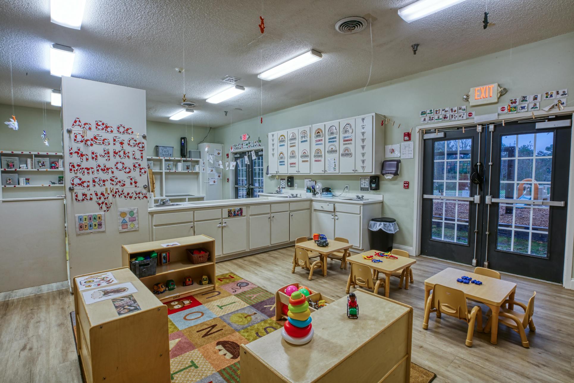 Empty colorful preschool classroom with small tables and chairs