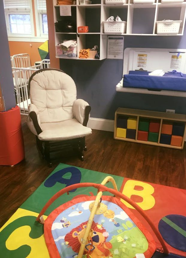 Nursery room with a rocking chair, changing table, and play mat