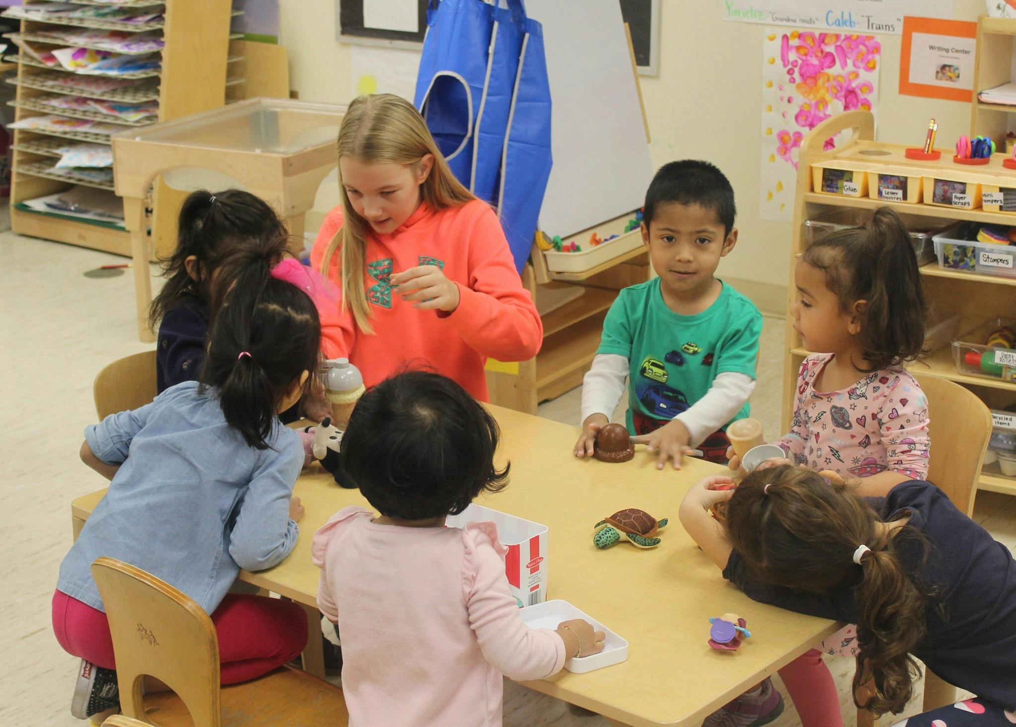 Teen and children sitting around a table